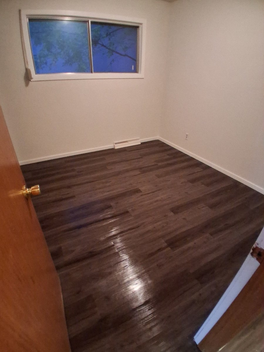 Freshly painted room with hardwood flooring by Royal Surface Painting, Calgary